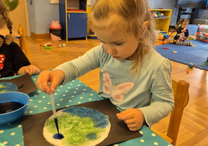 Dziewczynka maluje ziemie